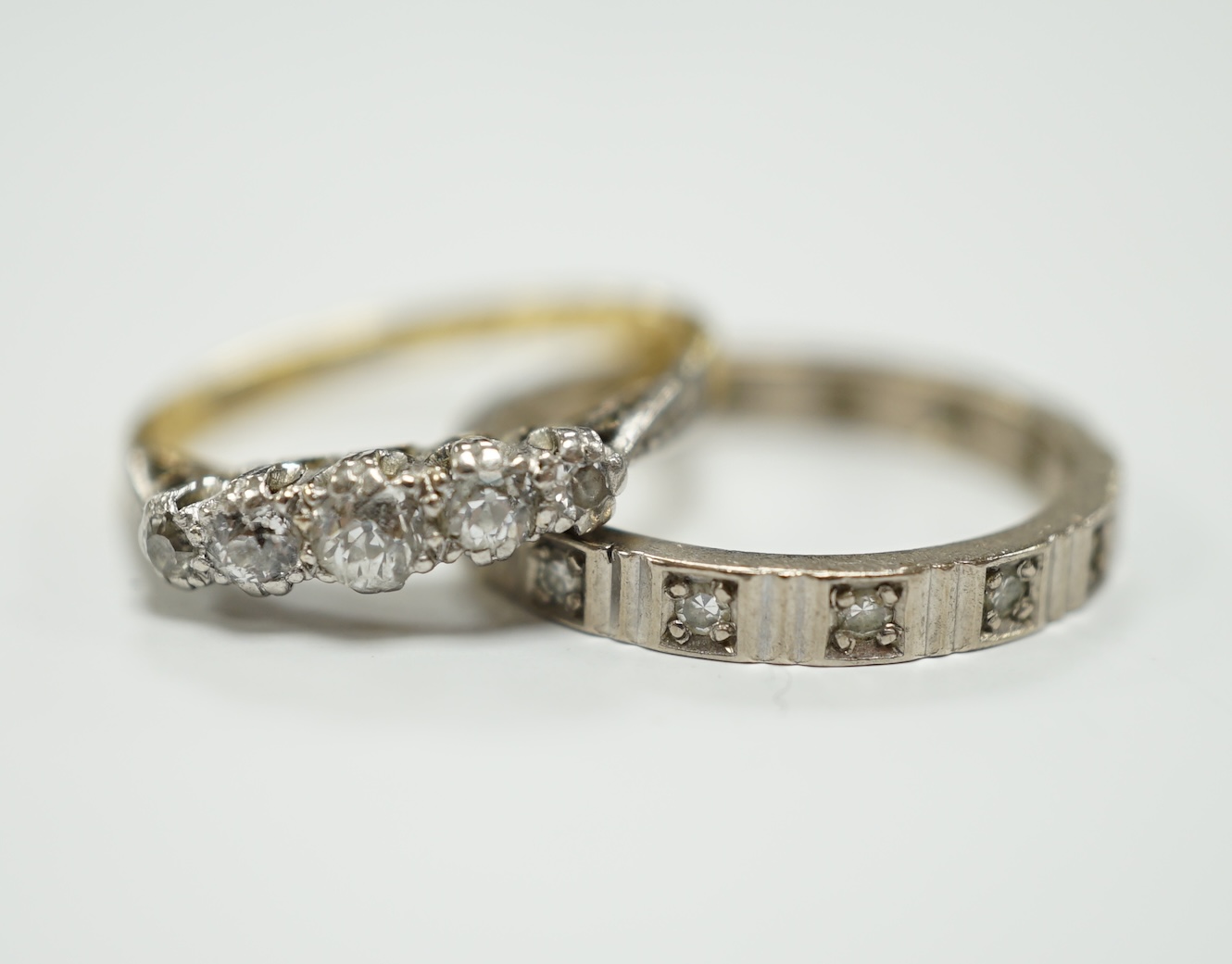 A 750 white metal and diamond chip set full eternity ring and an 18ct and graduated five stone diamond chip set ring, gross weight 6.6 grams.